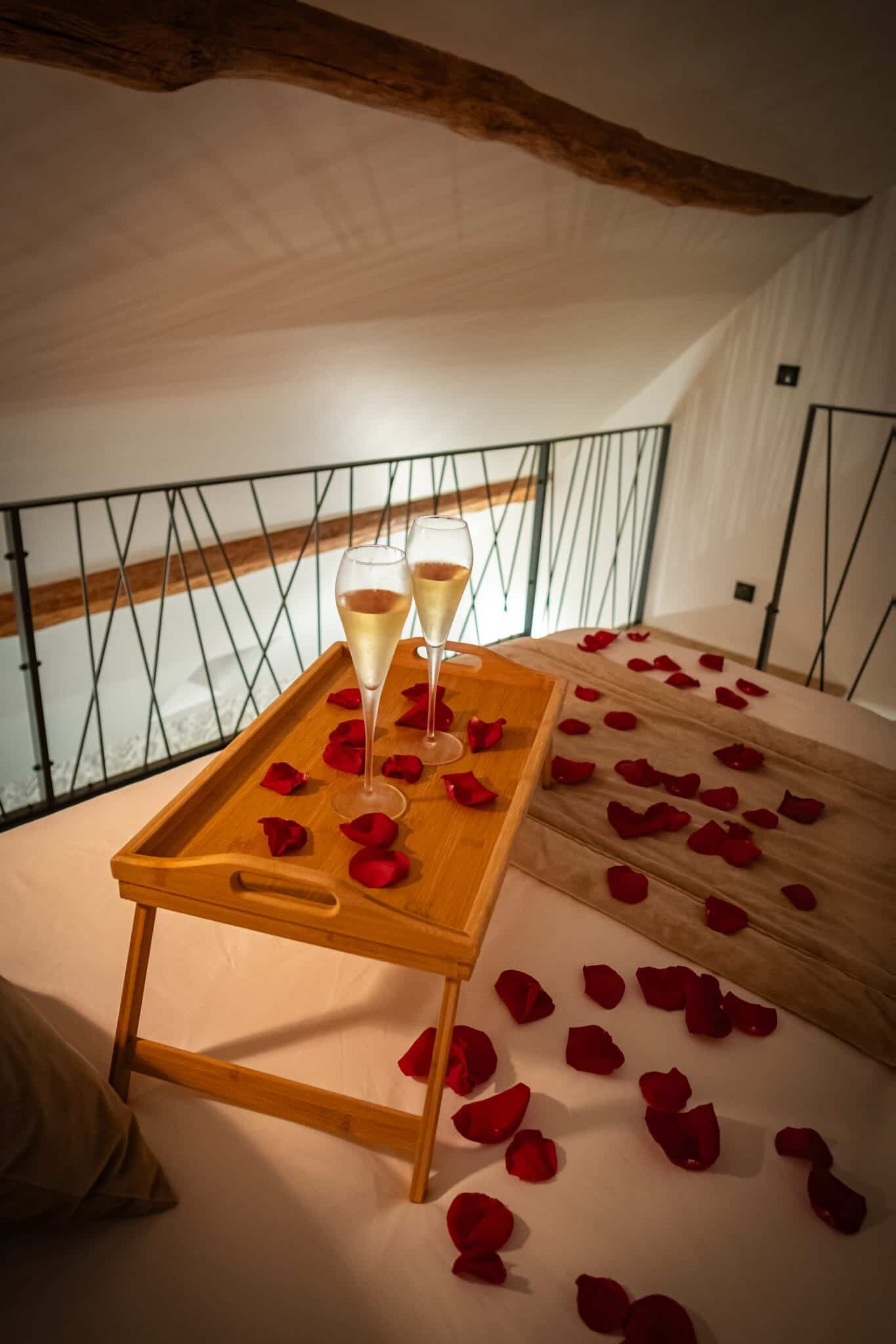 Petit-déjeuner romantique servi sur lit avec pétales de roses dans la suite La Douce en Normandie par La Parenthèse