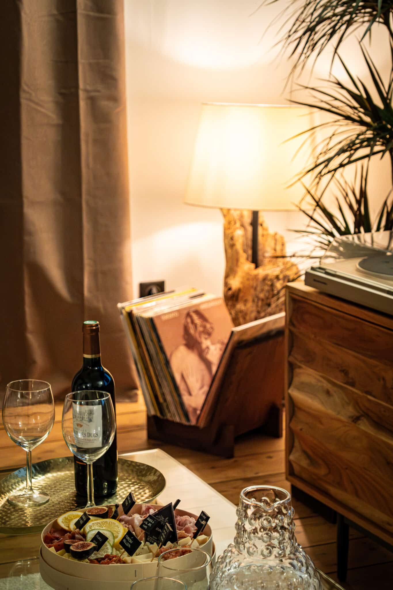 Bouteille de vin et ambiance chaleureuse dans la suite La Douce en Normandie par La Parenthèse