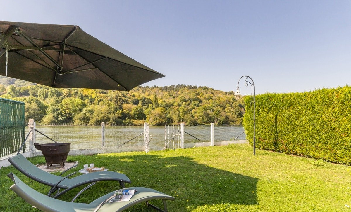 Vue sur le jardin privatif avec colline verdoyante au chalet La Parenthèse en Normandie